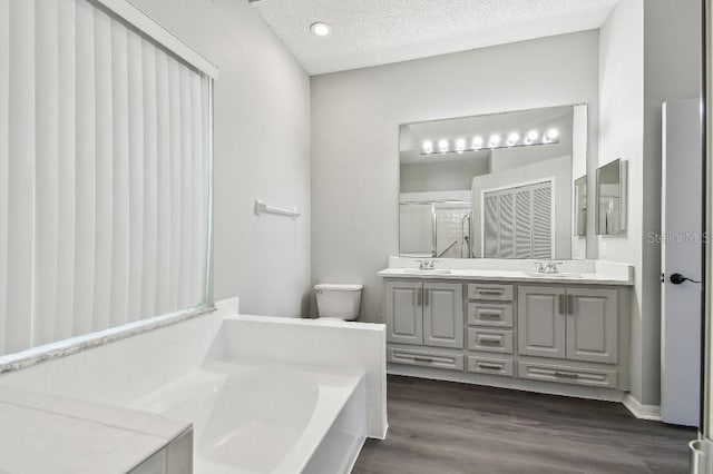 915 Brittany Park Blvd, Tarpon Springs, FL 34689 - bathroom featuring double vanity, a bath, toilet, a shower with shower door, and wood finished floors