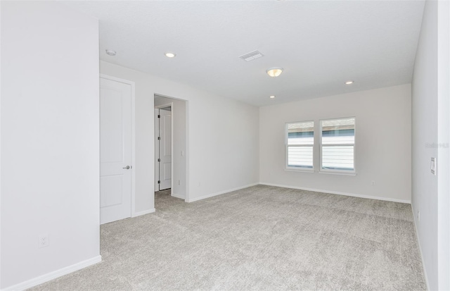 carpeted spare room with recessed lighting, visible vents, and baseboards