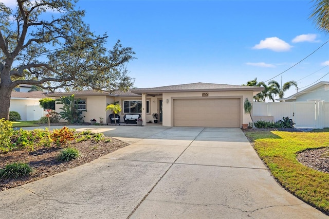 ranch-style house featuring stucco siding, concrete driveway, an attached garage, and fence