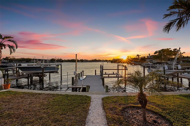 view of dock with boat lift, a yard, and a water view