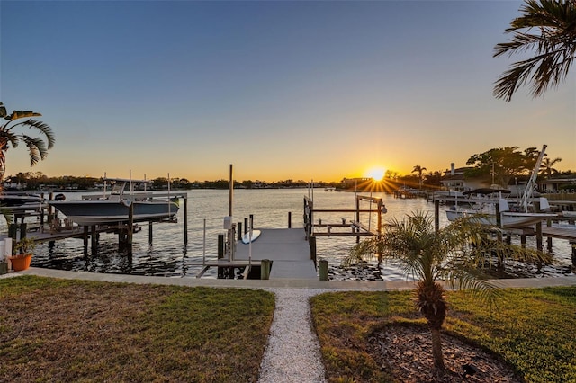 view of dock with a yard, a water view, and boat lift