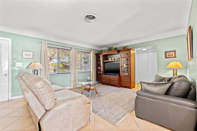 living area featuring light tile patterned floors, baseboards, and visible vents