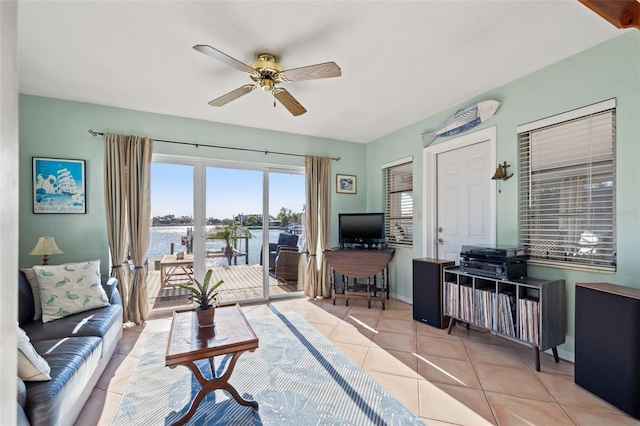 living area with tile patterned floors, baseboards, and a ceiling fan