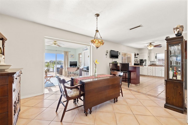 dining area with light tile patterned flooring, visible vents, baseboards, and ceiling fan