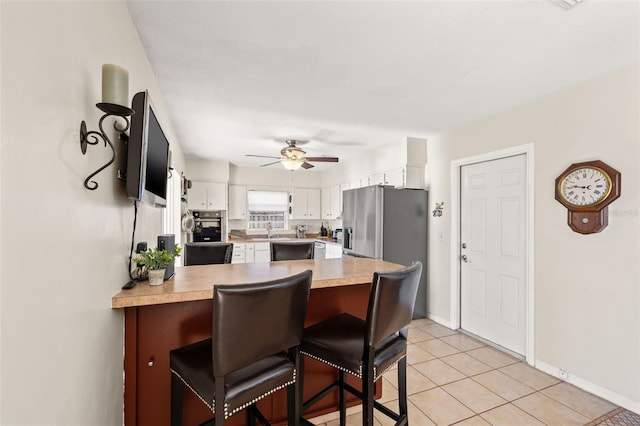 kitchen with white cabinetry, a peninsula, light countertops, and stainless steel appliances