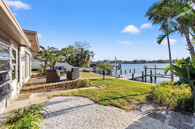 dock area featuring fence, an outdoor living space, a water view, boat lift, and a patio area