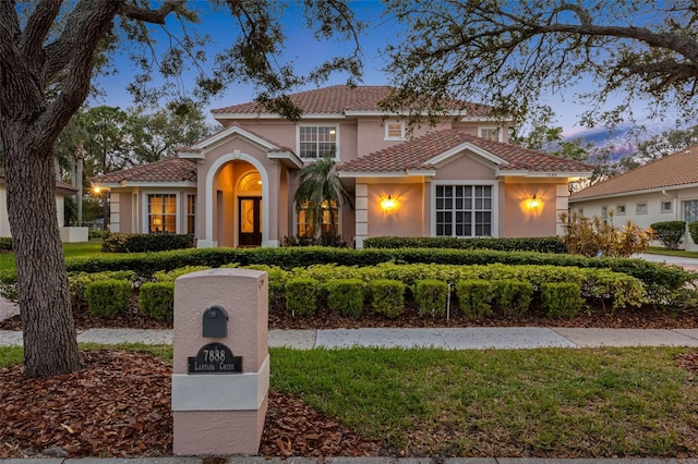 mediterranean / spanish-style house featuring a tile roof and stucco siding