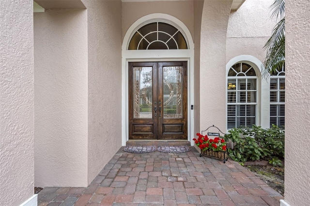 entrance to property featuring french doors and stucco siding