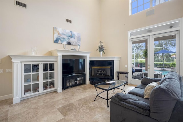 living room with plenty of natural light, visible vents, and french doors