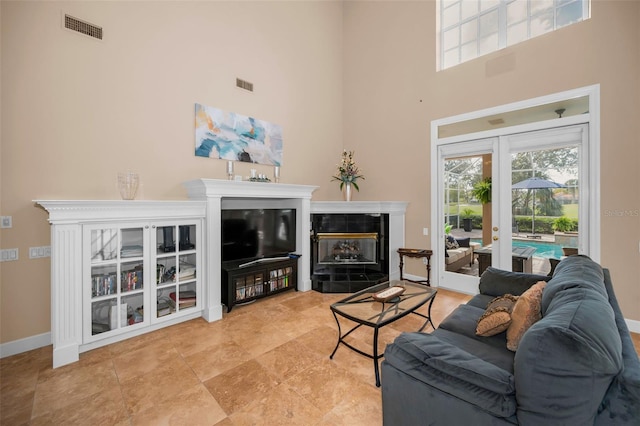 living area featuring baseboards, visible vents, and french doors