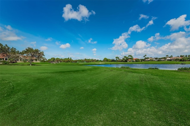 view of property's community featuring a lawn and a water view