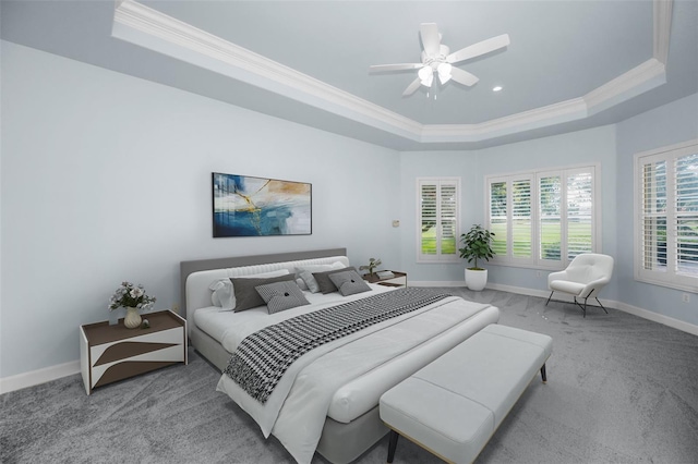 carpeted bedroom featuring ornamental molding, a raised ceiling, ceiling fan, and baseboards