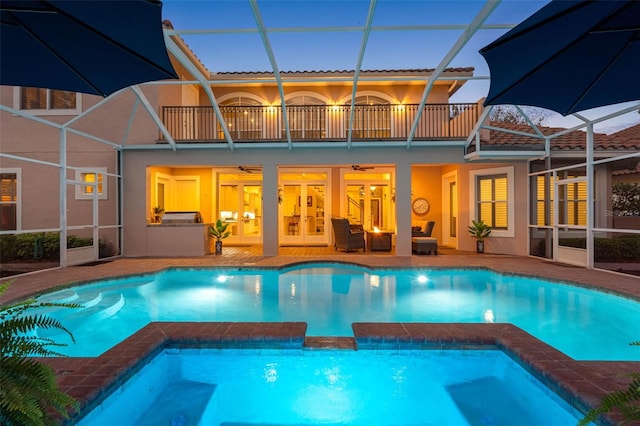 view of pool featuring a patio, a lanai, a pool with connected hot tub, and a ceiling fan