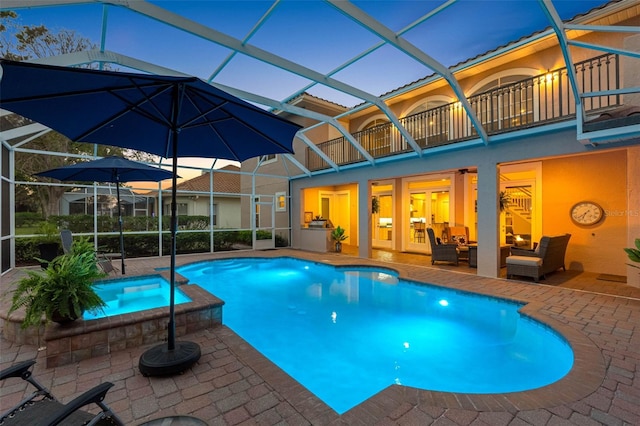 view of swimming pool featuring a lanai, a patio area, a pool with connected hot tub, and an outdoor living space