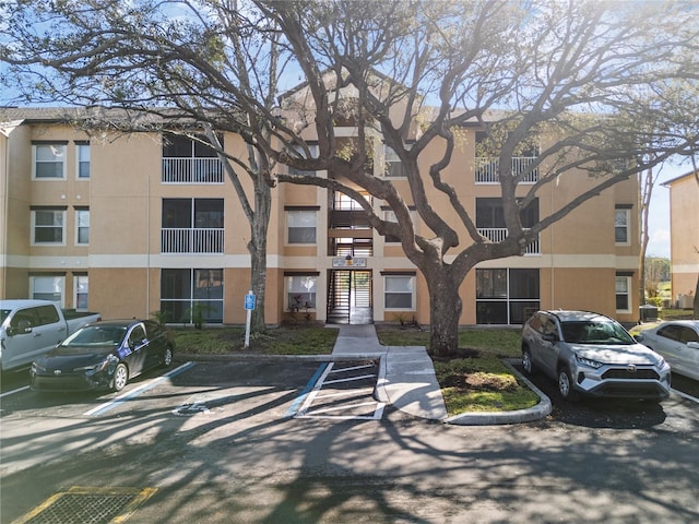 view of building exterior with uncovered parking