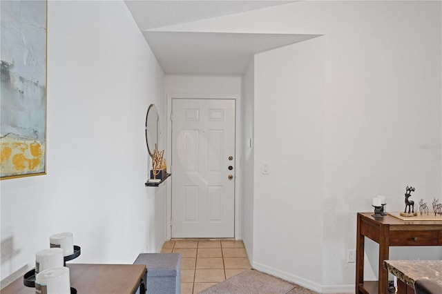 foyer with light tile patterned flooring and baseboards