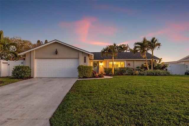 ranch-style house featuring a front yard, a gate, stucco siding, concrete driveway, and a garage