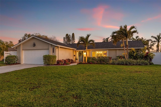 ranch-style house with a front yard, fence, driveway, an attached garage, and stucco siding