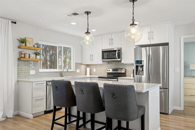 kitchen with visible vents, stainless steel appliances, light countertops, and a sink