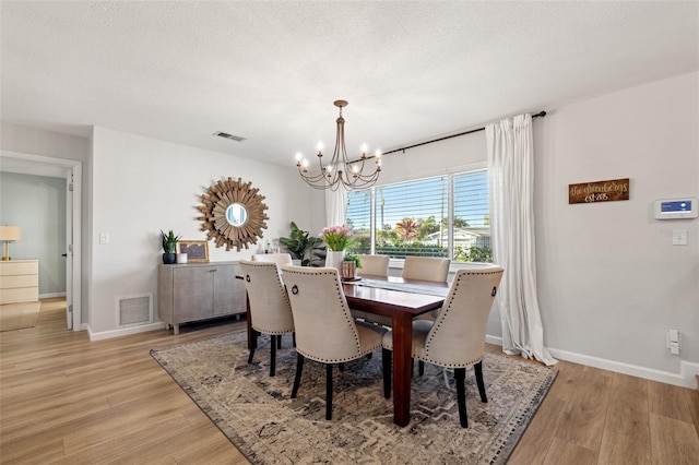 dining room featuring visible vents, an inviting chandelier, and light wood finished floors