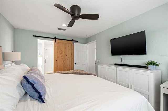 bedroom with a ceiling fan and a barn door