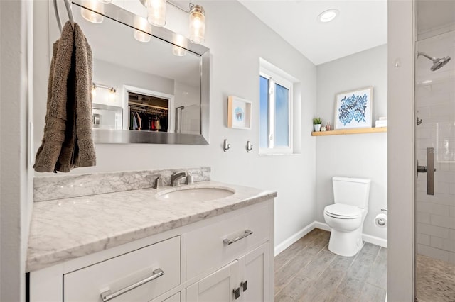 full bathroom featuring vanity, toilet, wood finished floors, and a shower stall