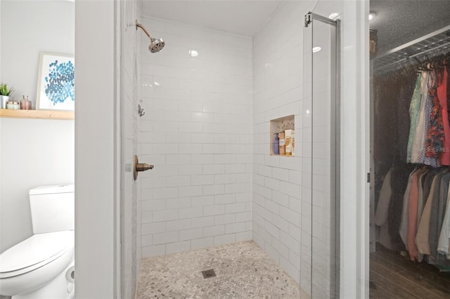 full bathroom with wood finished floors, toilet, and a stall shower