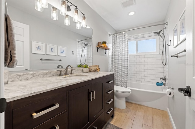 full bathroom featuring visible vents, toilet, wood finished floors, shower / bath combination with curtain, and vanity