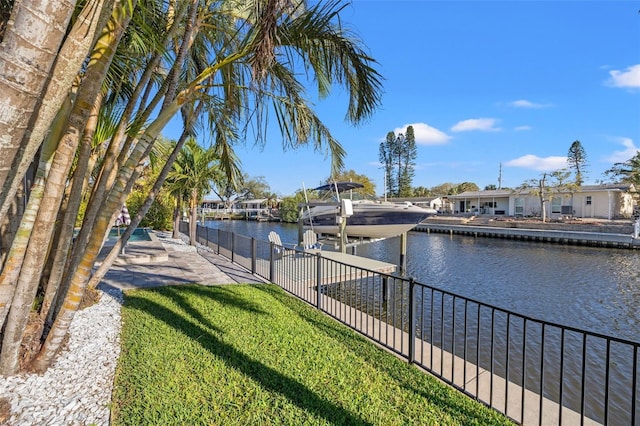 view of water feature with boat lift, a boat dock, and fence