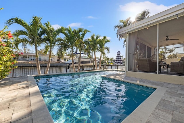 view of pool with a patio area, a fenced in pool, a ceiling fan, and a sunroom