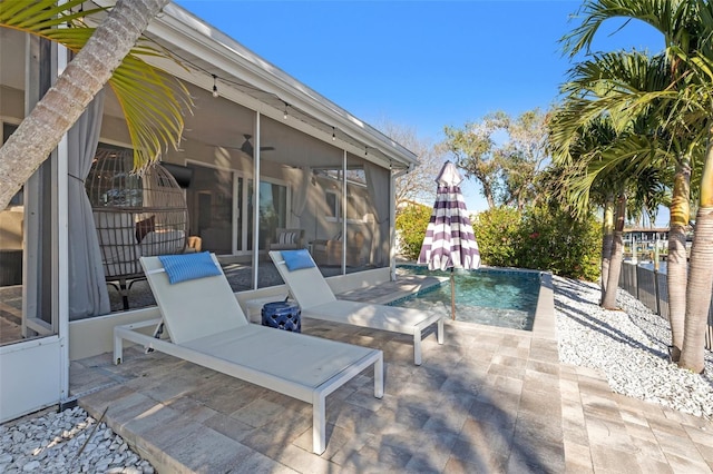 view of patio / terrace featuring fence and a sunroom