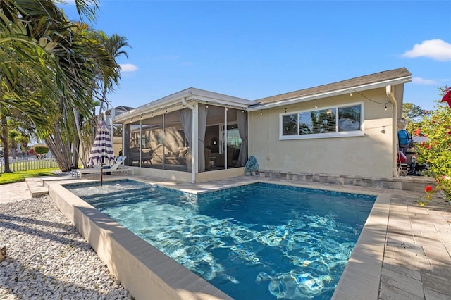 back of house featuring a patio area, stucco siding, fence, and a sunroom