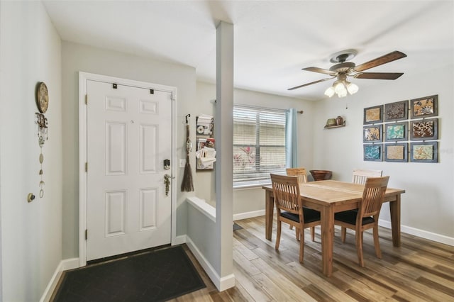 foyer entrance with ceiling fan, wood finished floors, and baseboards