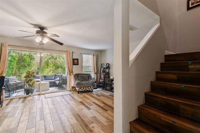 staircase featuring ceiling fan and wood finished floors