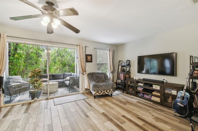 living room with light wood-style floors and a ceiling fan