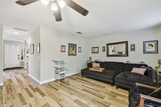 living room featuring baseboards, visible vents, and light wood finished floors