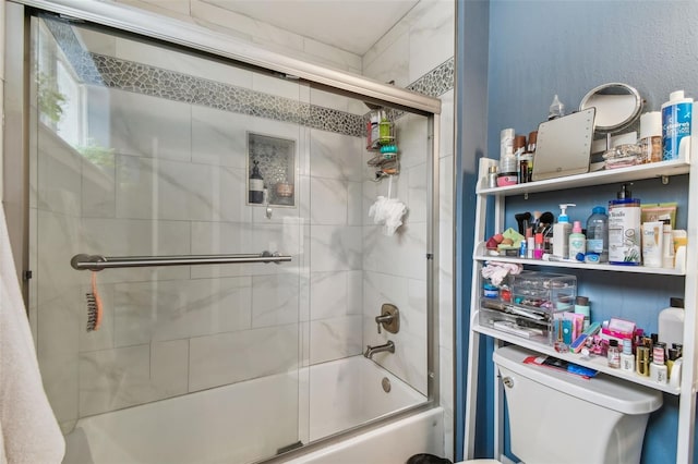 bathroom featuring enclosed tub / shower combo and toilet