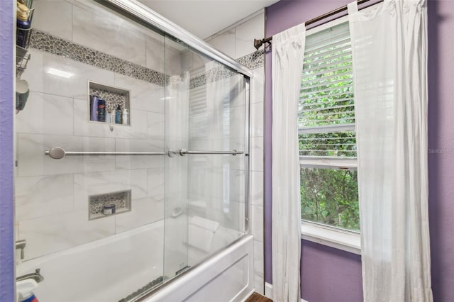 bathroom featuring shower / bath combination with glass door and a healthy amount of sunlight