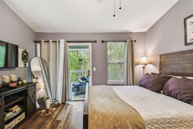 bedroom with dark wood-style floors and access to outside