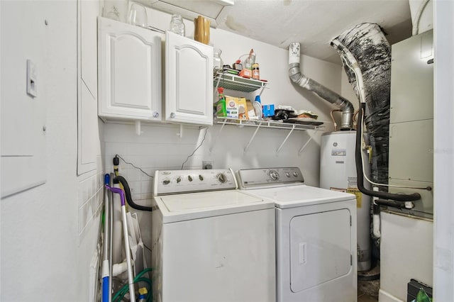 clothes washing area featuring cabinet space, washing machine and dryer, and water heater