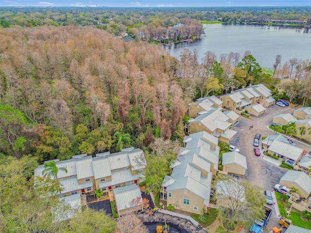 drone / aerial view featuring a water view, a forest view, and a residential view