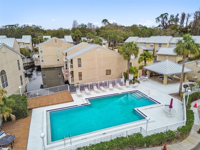 community pool with a residential view, a patio area, fence, and a gazebo