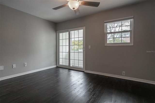 spare room with dark wood-style floors, plenty of natural light, baseboards, and ceiling fan