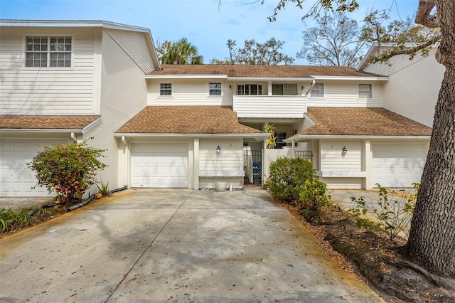 view of front of house with a garage, a shingled roof, fence, driveway, and stucco siding