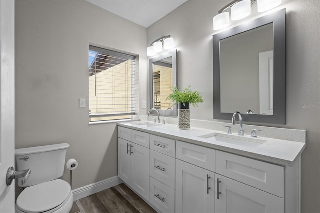 bathroom with wood finished floors, a sink, toilet, and baseboards