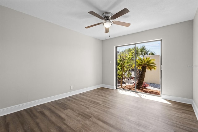 unfurnished room with a ceiling fan, baseboards, and dark wood-style flooring