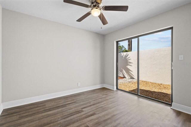 spare room with wood finished floors and baseboards