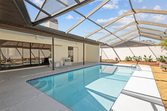 outdoor pool featuring a lanai, a patio area, and ceiling fan