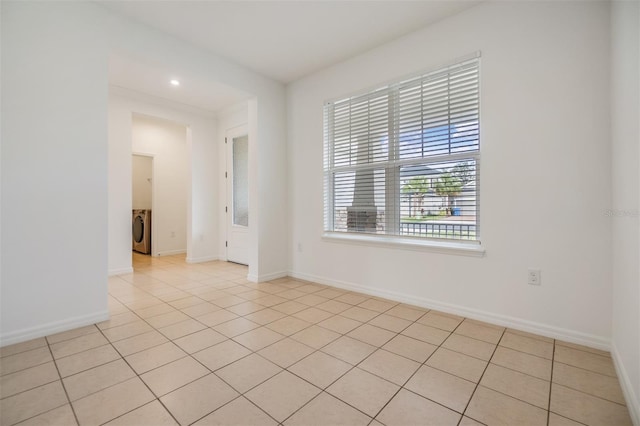 empty room with washer / dryer, light tile patterned floors, baseboards, and recessed lighting