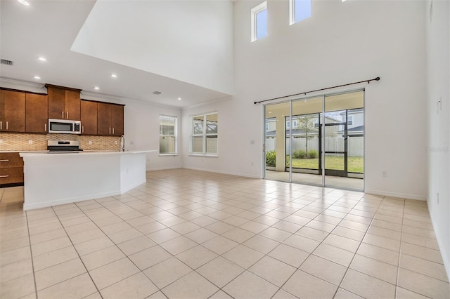 unfurnished living room featuring recessed lighting, light tile patterned flooring, visible vents, and baseboards